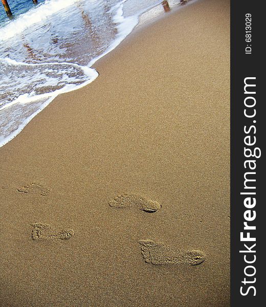 Human footprints leading into the sea