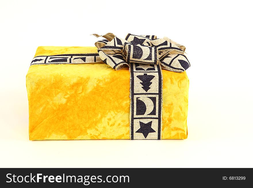 Christmas present in yellow original paper with beautiful tie