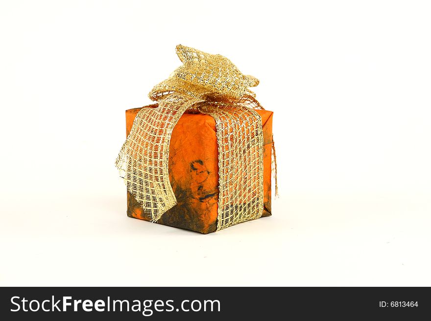 Small christmas present in orange paper with golden tie. Small christmas present in orange paper with golden tie