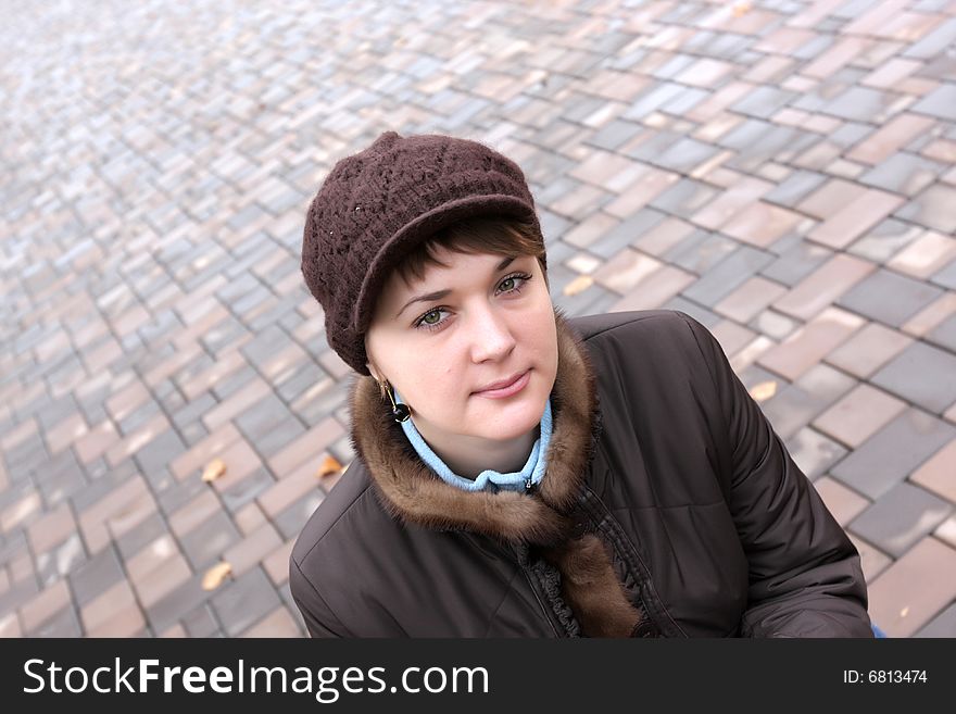 Autumnal portrait of young woman on sidewalk background