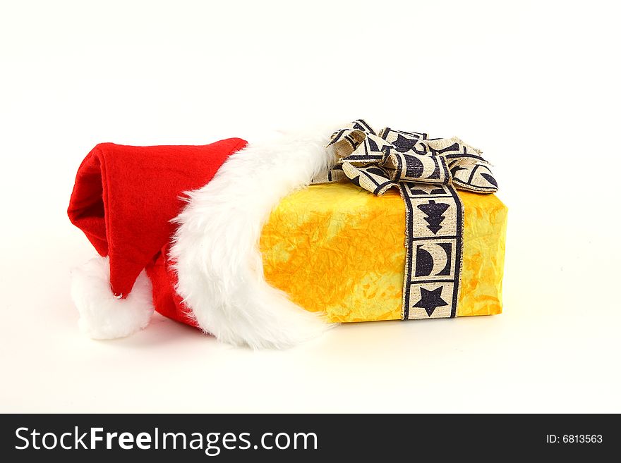 Yellow christmas present in santa's cap on white background