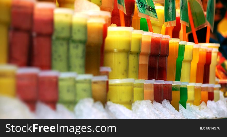 Different fresh fruit juices on a tropical fruit market