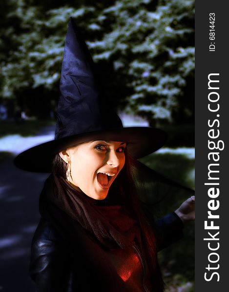 Screaming witch in a hat over darness