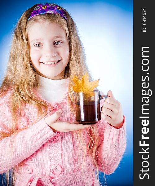 Cute little girl with tea cup and leaf