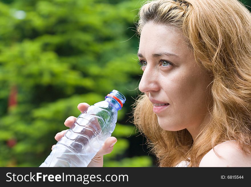 Pretty woman drinking water outdoors