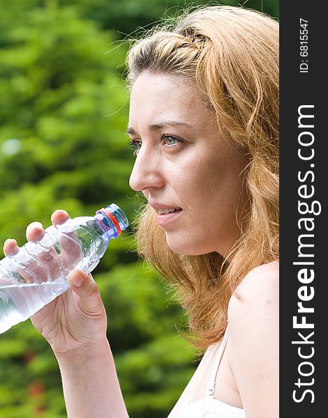 Pretty woman drinking water outdoors