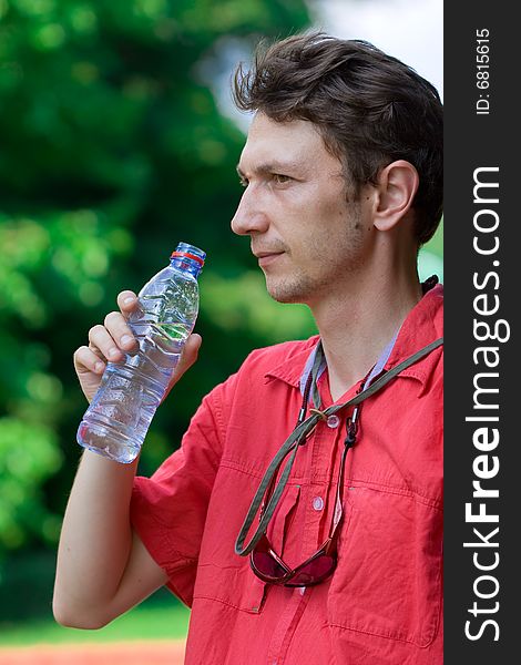 Man drinking water over a green background