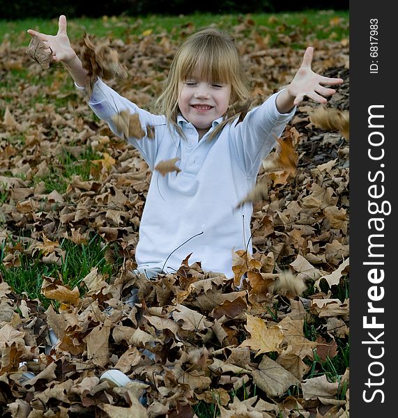 Four year old child playing in the autumn leaves. Four year old child playing in the autumn leaves