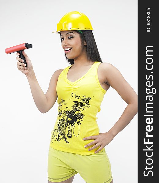 Female construction worker of indian origin with a painting roller. Female construction worker of indian origin with a painting roller