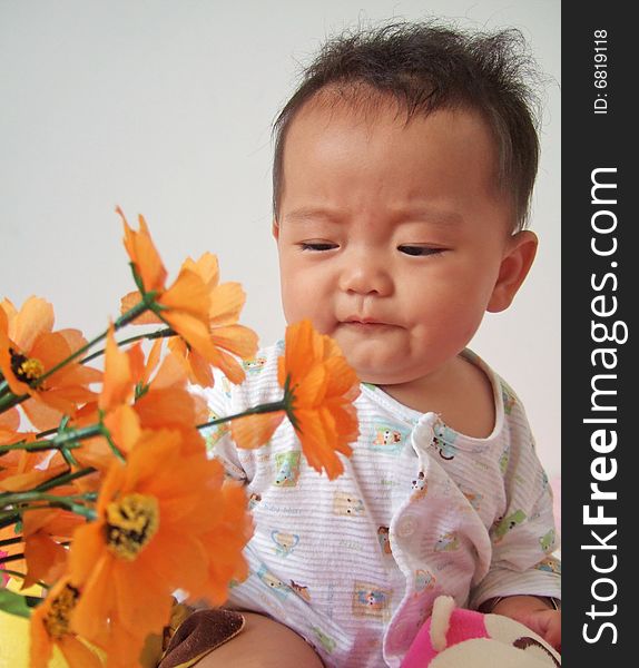 A cute baby and flowers. A cute baby and flowers