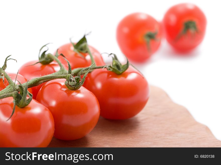 Ripe tomatoes over wood board isolated on white