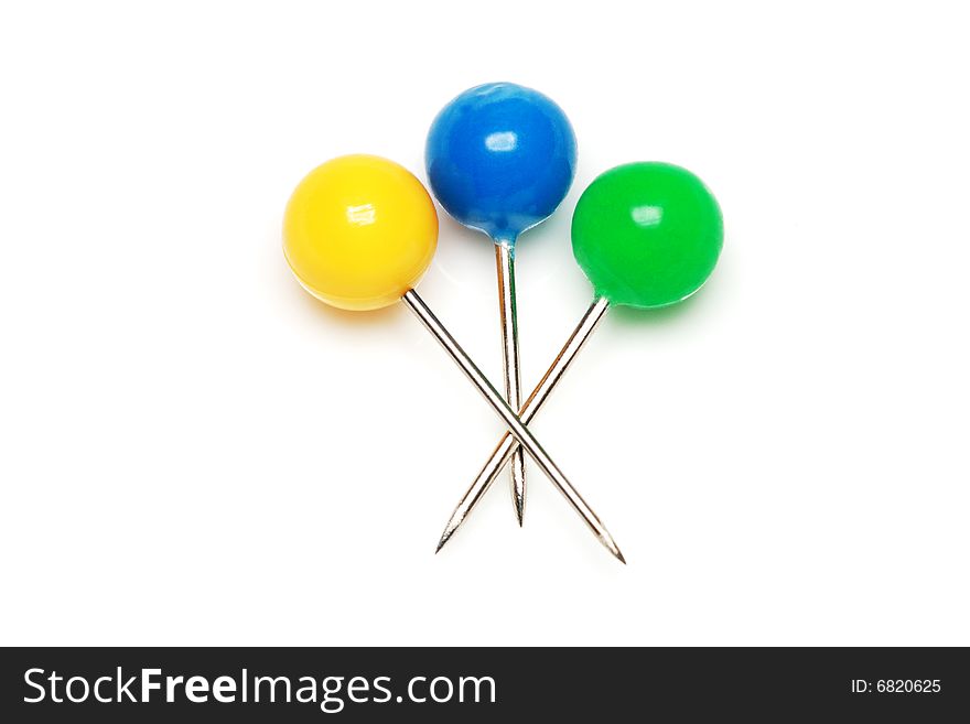 Yellow, blue and green push pins isolated on white background.