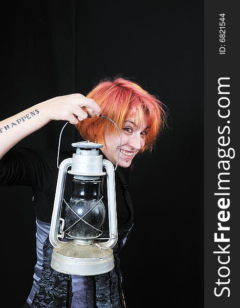 Happy red hair girl with lamp on black background