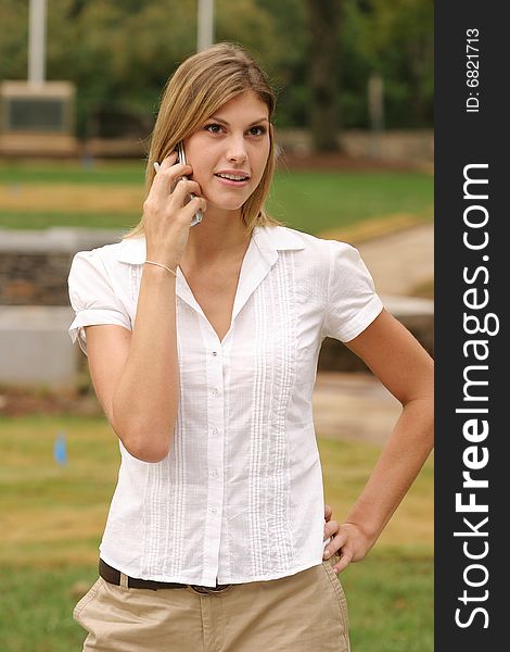 Young woman making a call using a cell phone. Young woman making a call using a cell phone