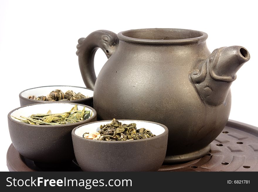 Teapot and three bowls of herbal tea. Close-up, isolated on white. Teapot and three bowls of herbal tea. Close-up, isolated on white.