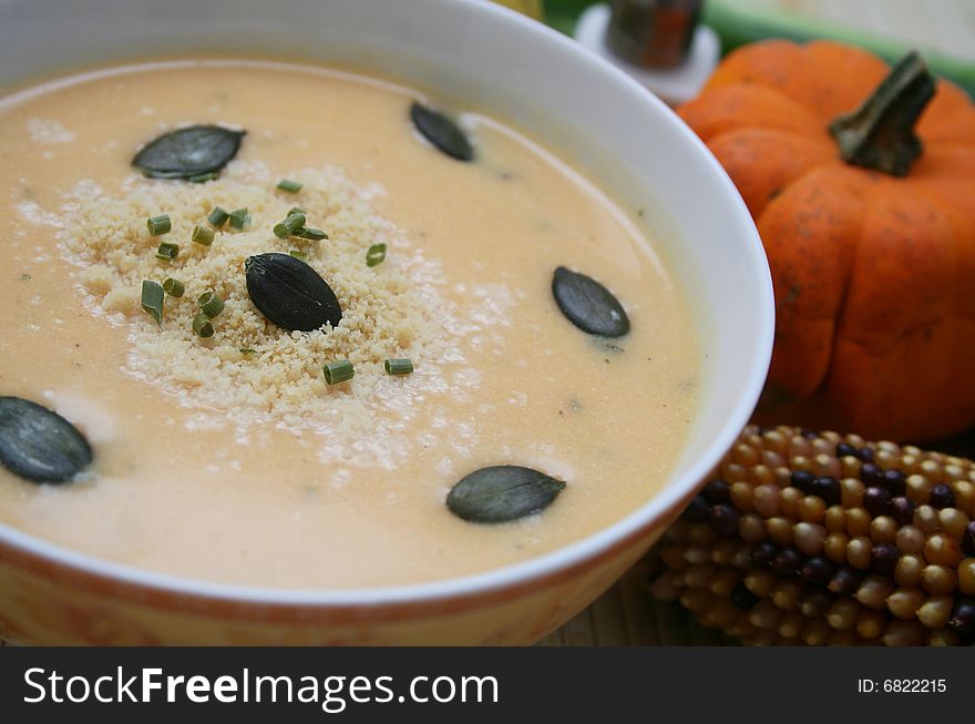 A fresh soup of a pumpkin with some pumpkin corns