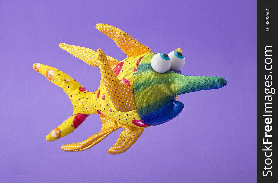 Toy fish isolated on violet background