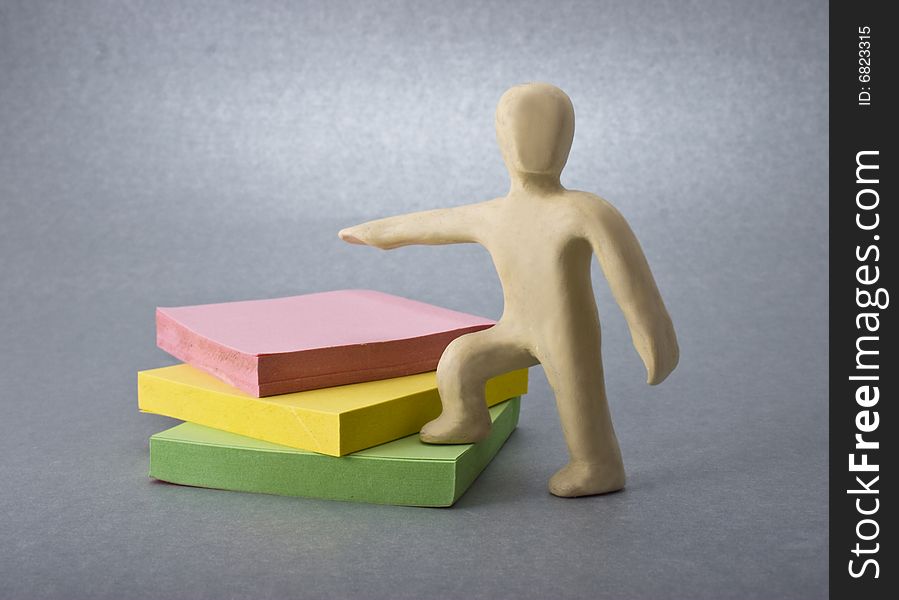 Plasticine man and notes close-up isolated on violet background