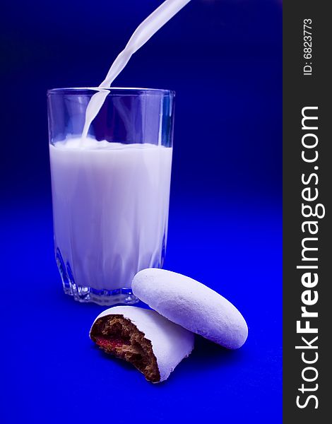 Cakes and glass of milk close-up isolated on violet background