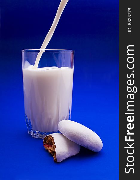 Cakes and glass of milk close-up isolated on violet background