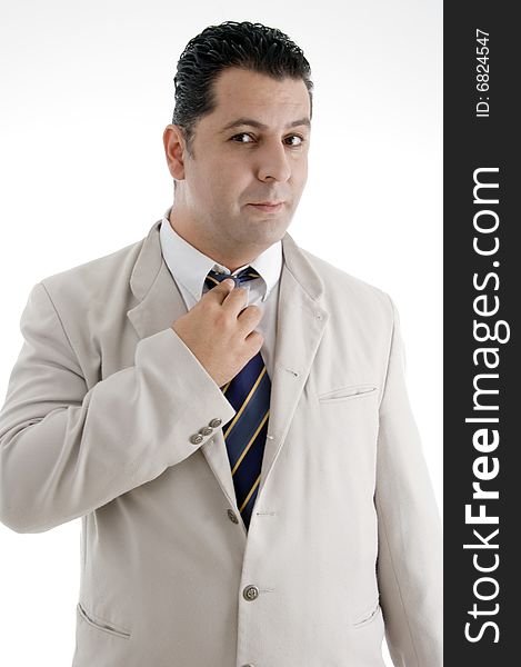 Businessman adjusting his tie and looking to camera on an isolated white background
