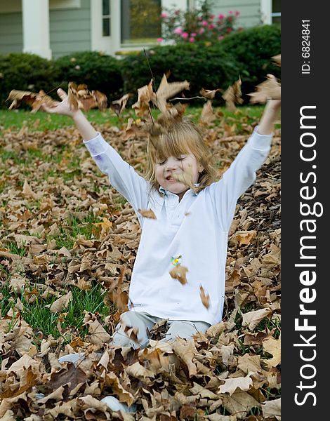 Four year old child playing in the autumn leaves. Four year old child playing in the autumn leaves