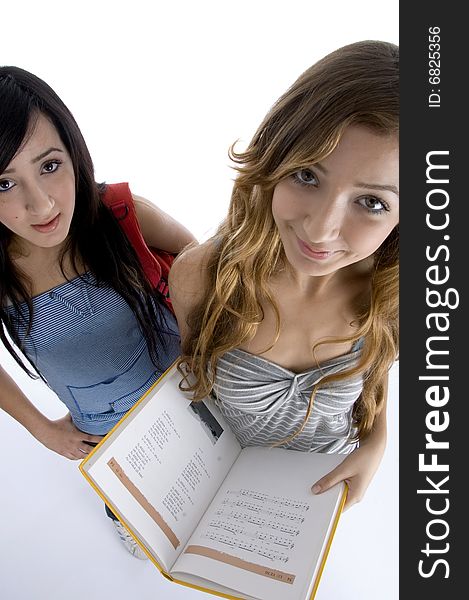 Young friends with book looking at camera on  an isolated white background