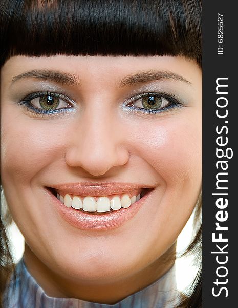 Portrait of pretty smiling brunette with composition accent on eyes and teeth. Portrait of pretty smiling brunette with composition accent on eyes and teeth