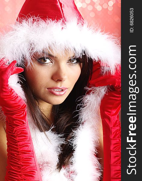 Christmas girl wearing santa claus costume over red background. Christmas girl wearing santa claus costume over red background