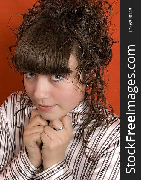 Timid girl with curly hair over red background