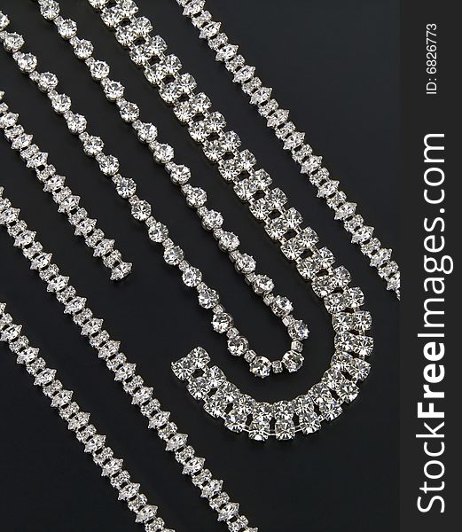 Display of silver necklaces and bracelets with shiny gemstones. Display of silver necklaces and bracelets with shiny gemstones