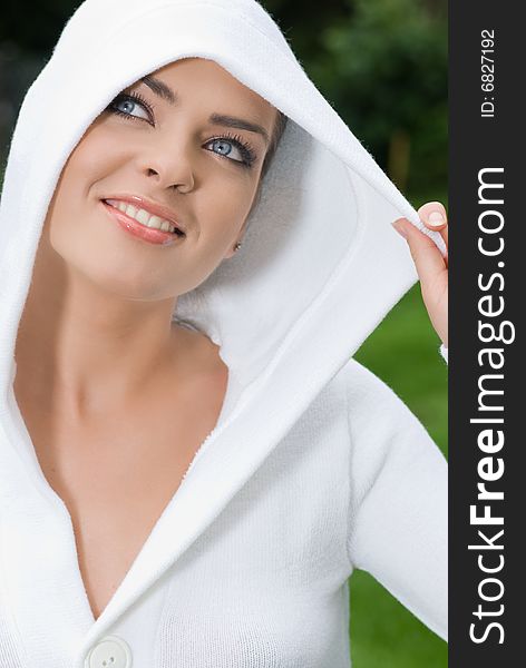 Woman wearing white sweater relaxing outdoor. Woman wearing white sweater relaxing outdoor