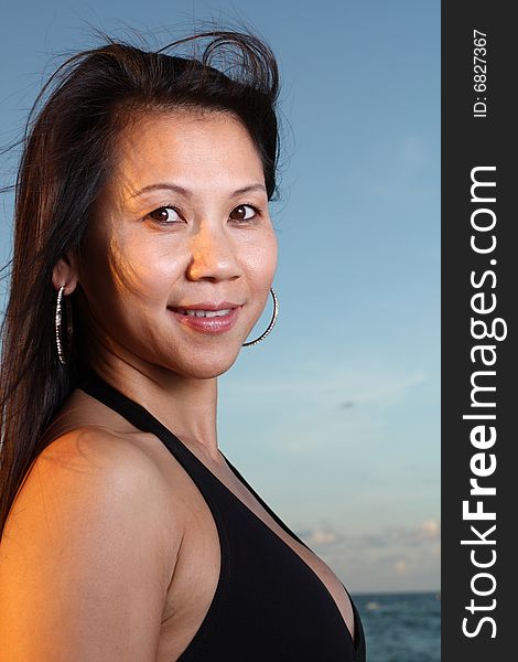 Young female smiling with a beautiful blue sky background. Young female smiling with a beautiful blue sky background