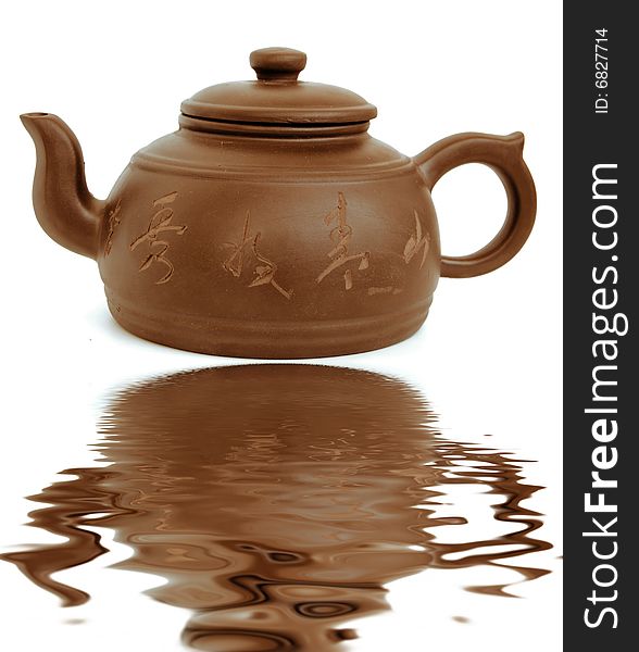 Classic chinese teapot of brown clayand reflection in water