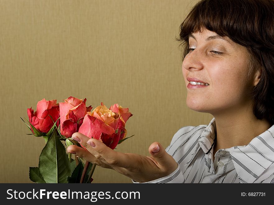 There is woman look on the flowers and smile. There is woman look on the flowers and smile