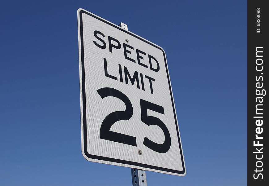 A speed limit sign with a deep blue sky in background. A speed limit sign with a deep blue sky in background