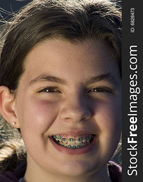 Headshot of girl smiling while wearing braces. Headshot of girl smiling while wearing braces