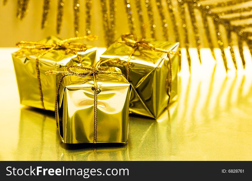 Gift boxes on golden background with leaf