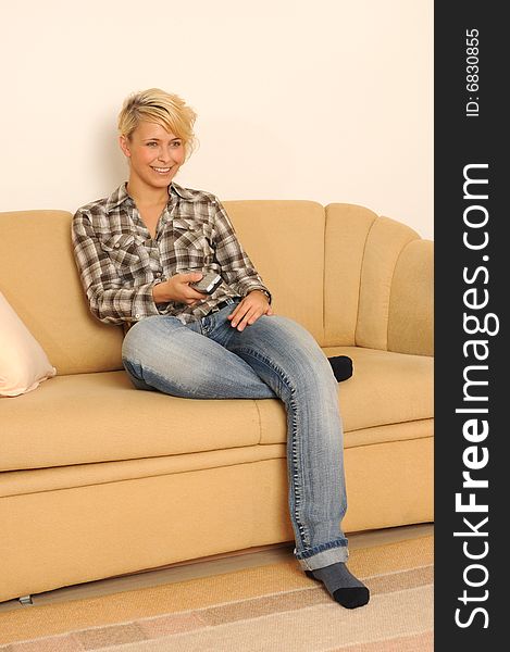 Young woman sitting on a couch watching TV. Young woman sitting on a couch watching TV.