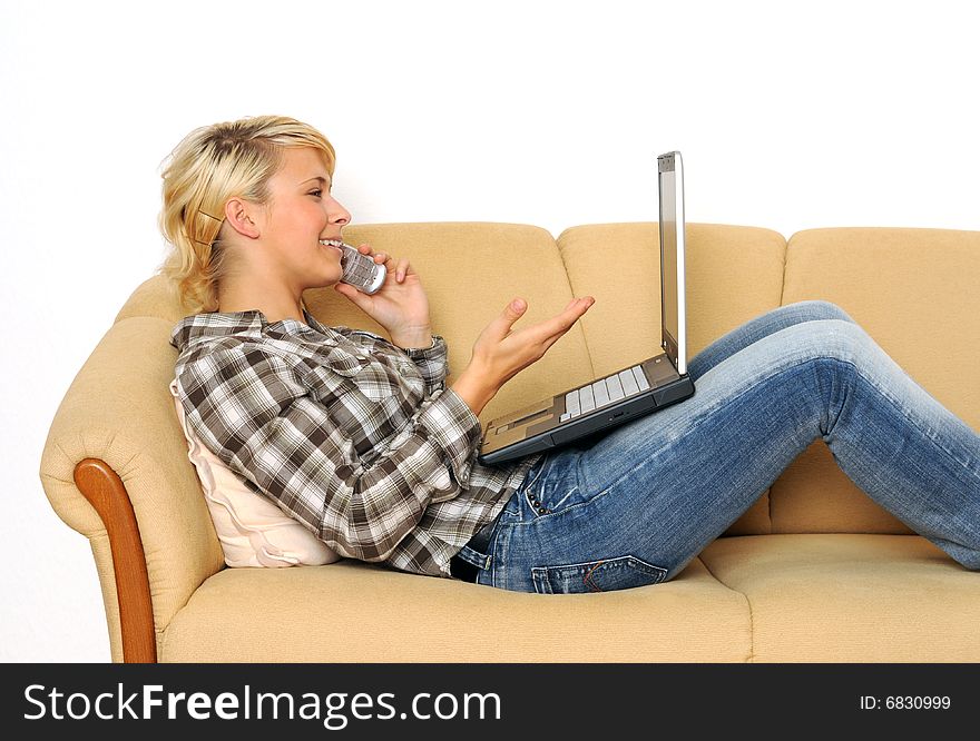 Young woman working with her laptop, sitting on a sofa. Young woman working with her laptop, sitting on a sofa.