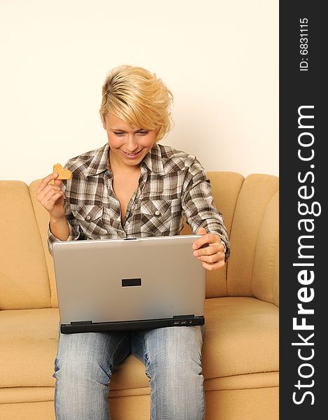 Young woman working with her laptop, sitting on a sofa. Young woman working with her laptop, sitting on a sofa.