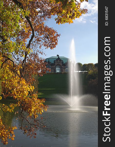 Trees, leafs, pond and fountain in autumn scene in town. Dresden, Germany. Vertical. Trees, leafs, pond and fountain in autumn scene in town. Dresden, Germany. Vertical.