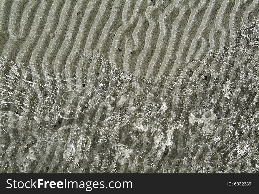 Background with wet grey sand and water. Background with wet grey sand and water