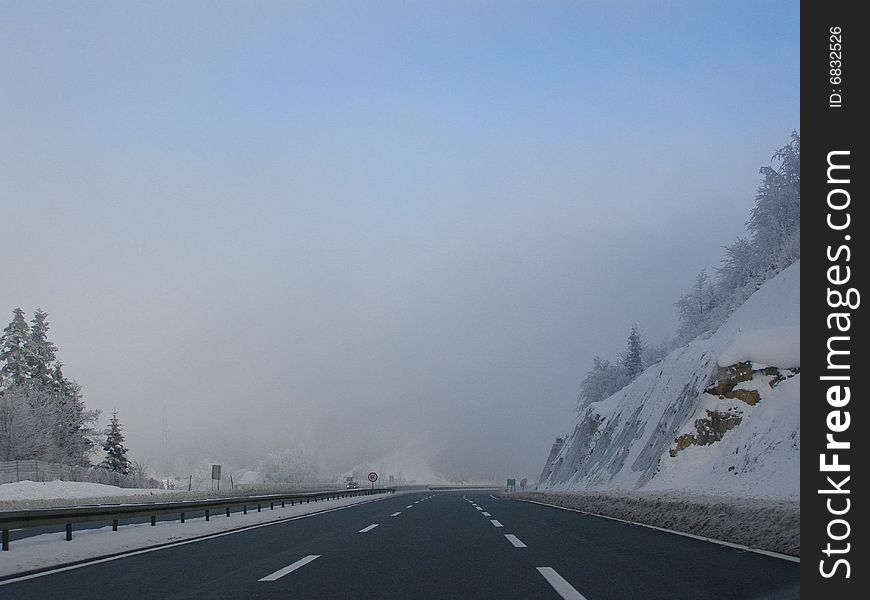 Highway, snow and fog at dusk, bad winter driving conditions

*with space for text (copyspace)