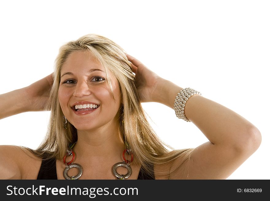 A blonde smiling and pulling her hair back. A blonde smiling and pulling her hair back