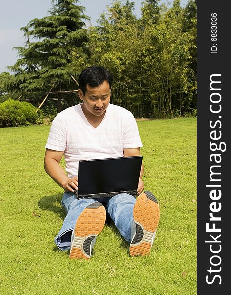 A young man using a laptop outdoors