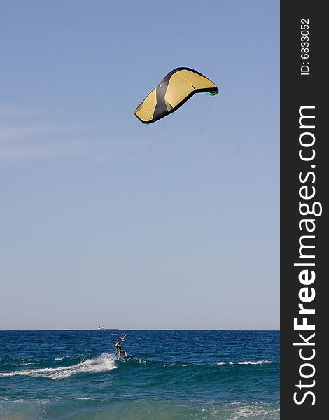 A beach scene with a surf kite in the air. A beach scene with a surf kite in the air