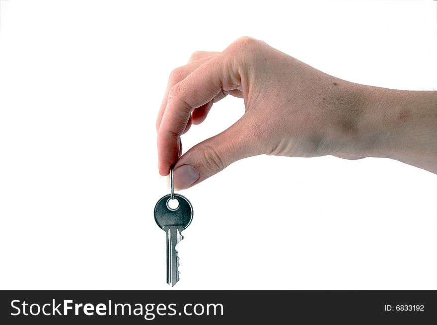 An isolated image of one key hanging from a hand. An isolated image of one key hanging from a hand