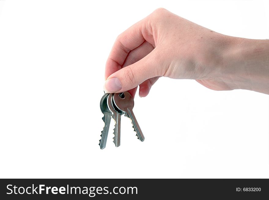 An isolated image of three keys hanging from a hand. An isolated image of three keys hanging from a hand