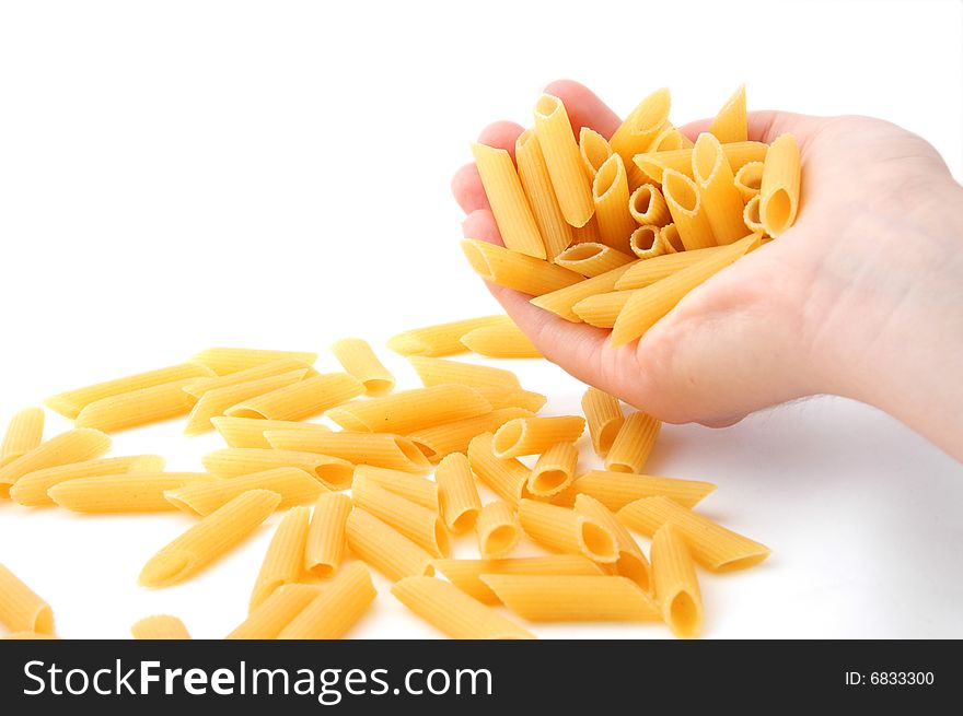 An Isolated image of a hand spilling a handful of pasta. An Isolated image of a hand spilling a handful of pasta